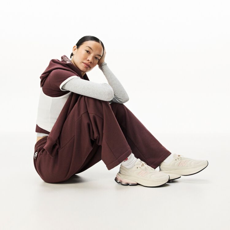 A woman sitting down on the ground with her head resting on her hand